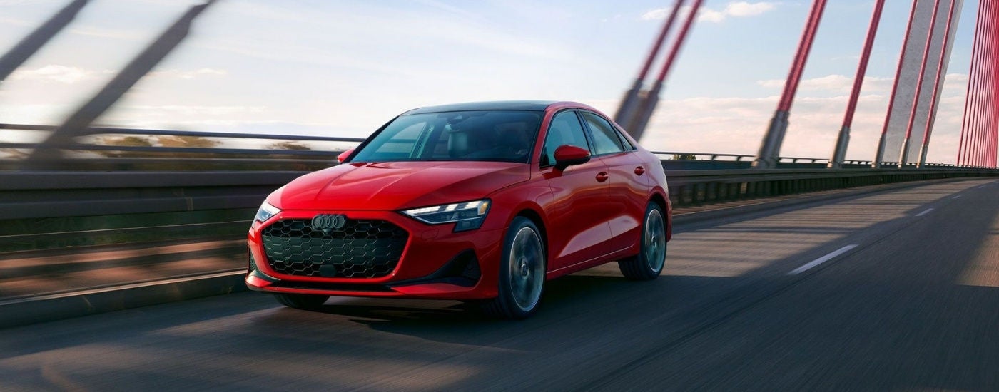 Red 2025 Audi A3 driving on a bridge